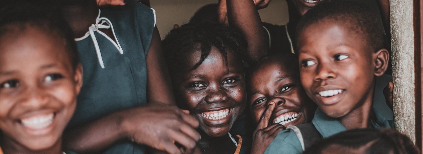 family of children standing in doorway laughing